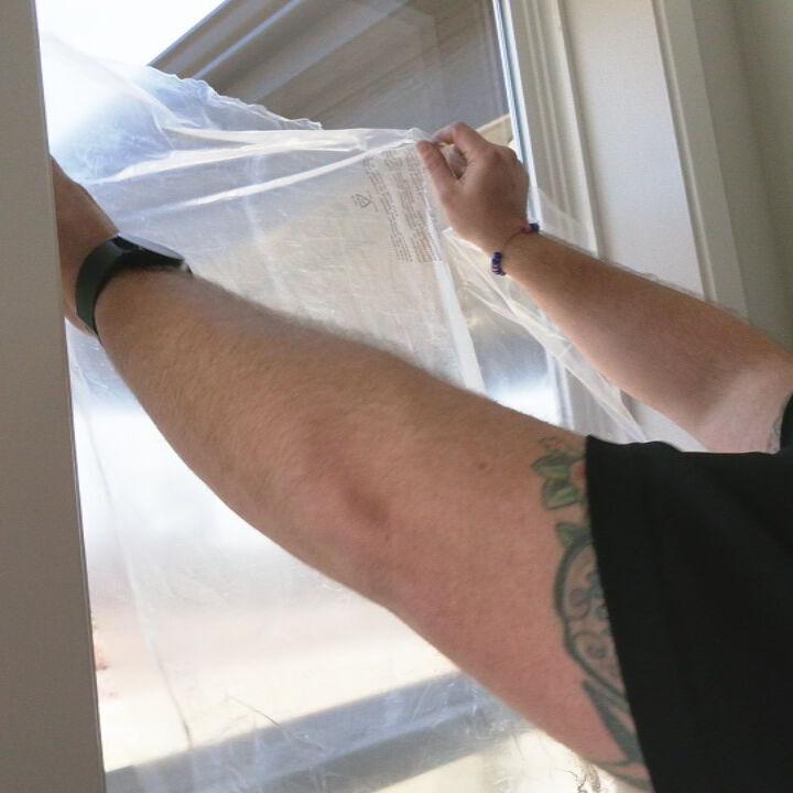 Jamason Welker with Bryant Heating and Cooling seals windows with plastic cover.